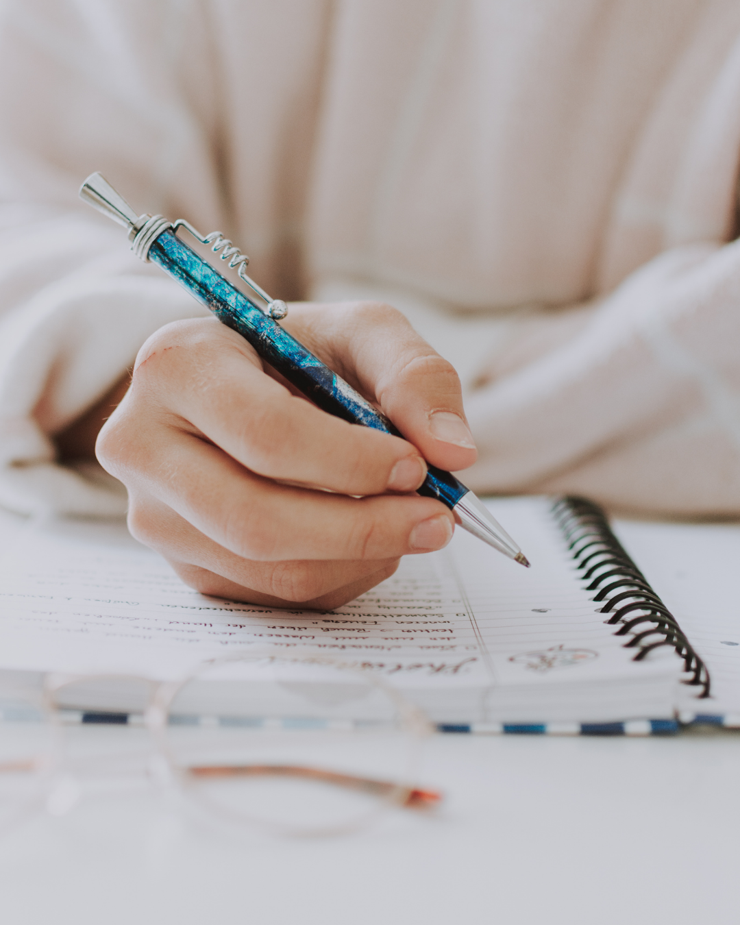 A close up view of a hand writing in a planner